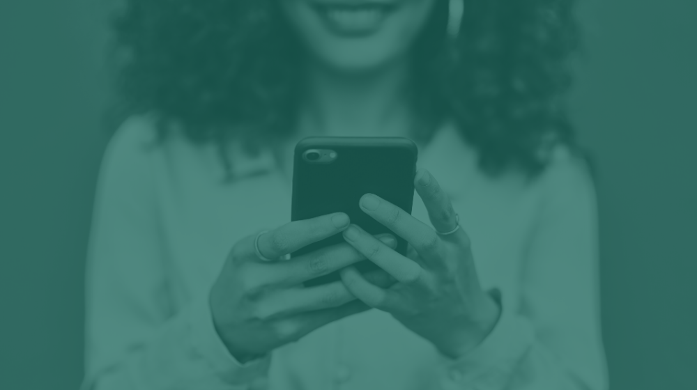 girl smiling at phone green mask