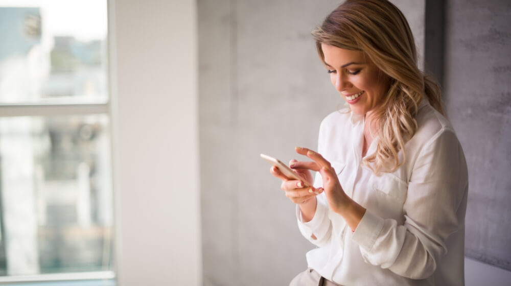 blonde woman smiling at phone